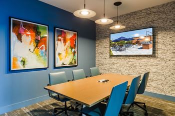 A conference room with a table and chairs and pictures on the wall
